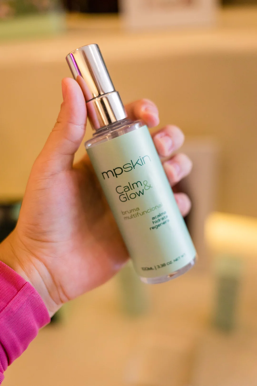 Frasco de Bruma Calm & Glow de 100 ml segurado na mão
