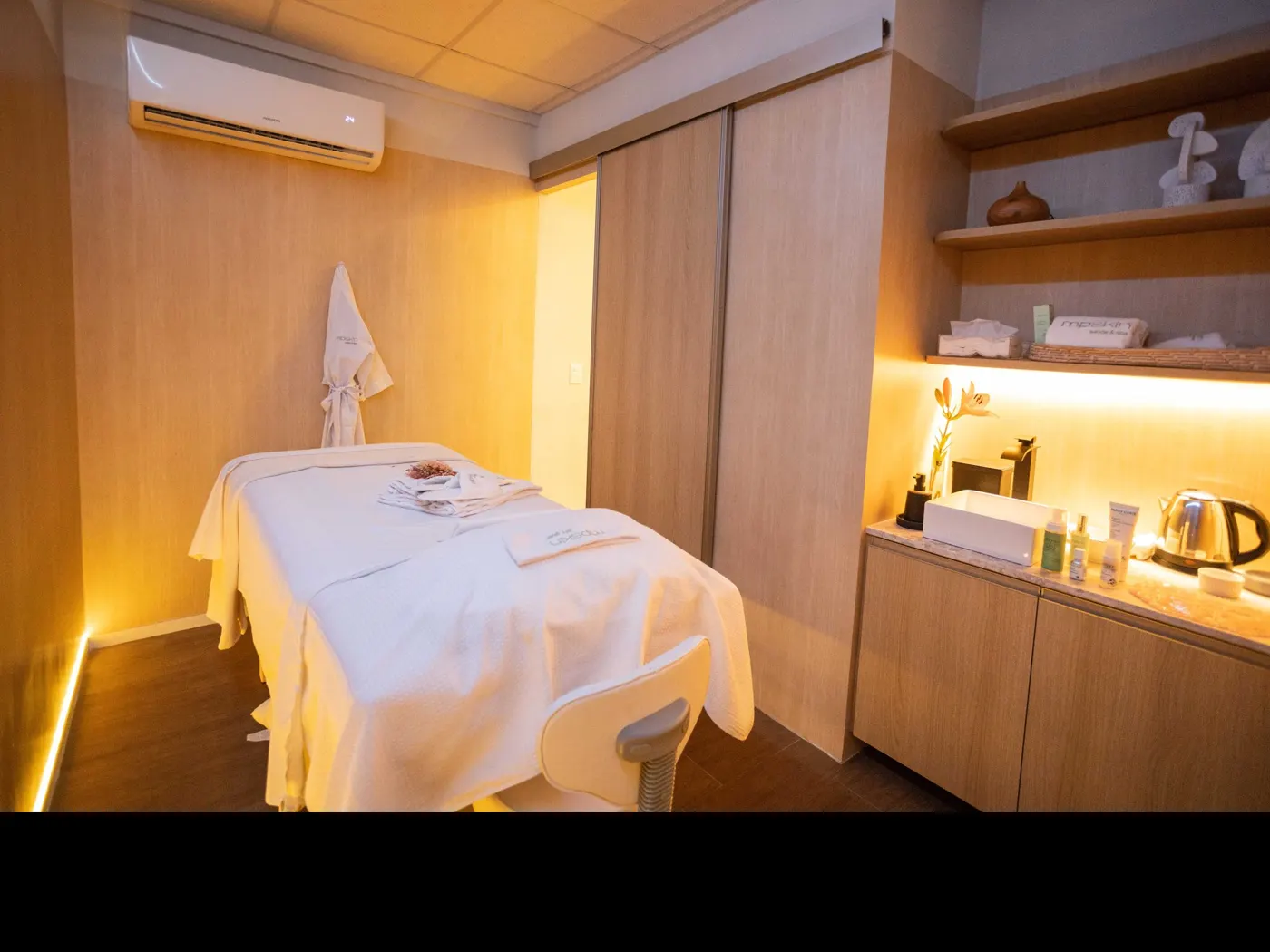 Sala de massagem da mp skin, em madeira clara e luz quente